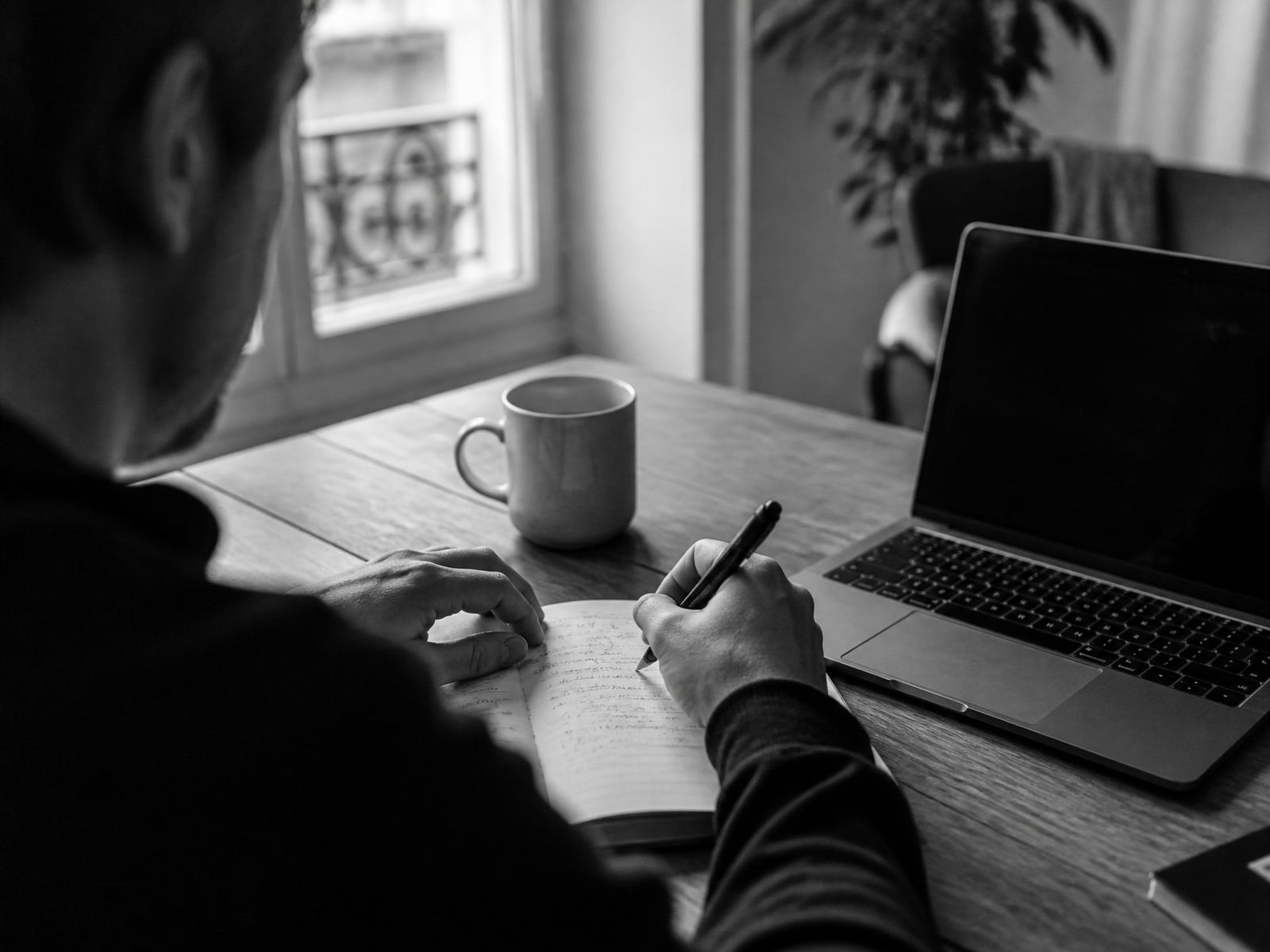Online personal trainer reviewing a client's weekly check-in and programme on a laptop
