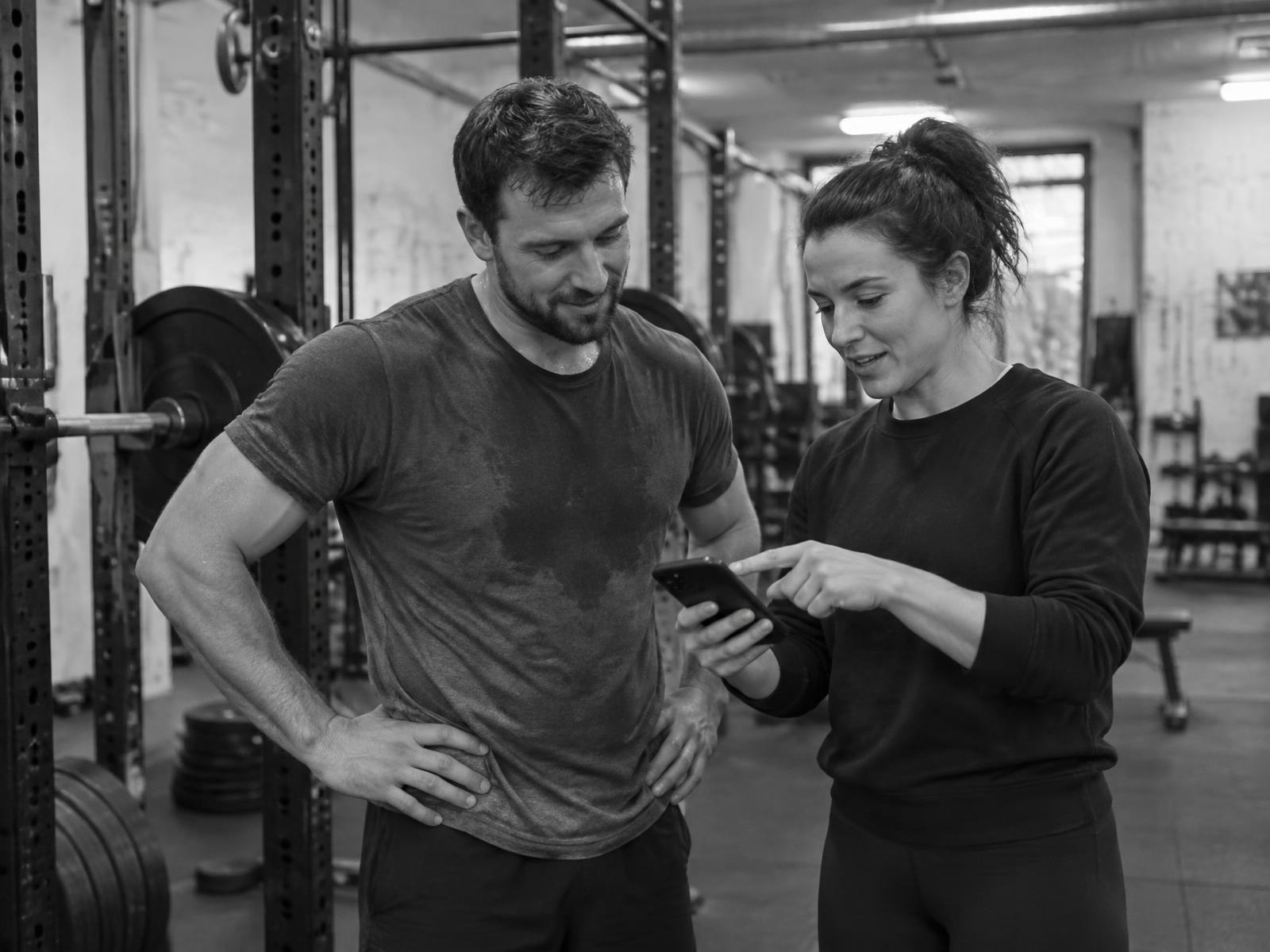 Coach and client reviewing a video replay of a strength set together
